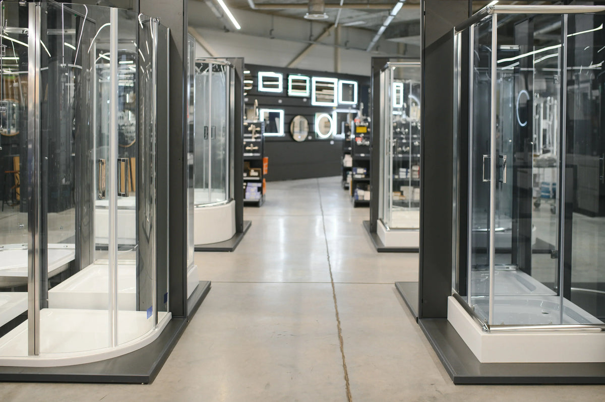 Modern glass shower enclosures on display in a bathroom showroom.