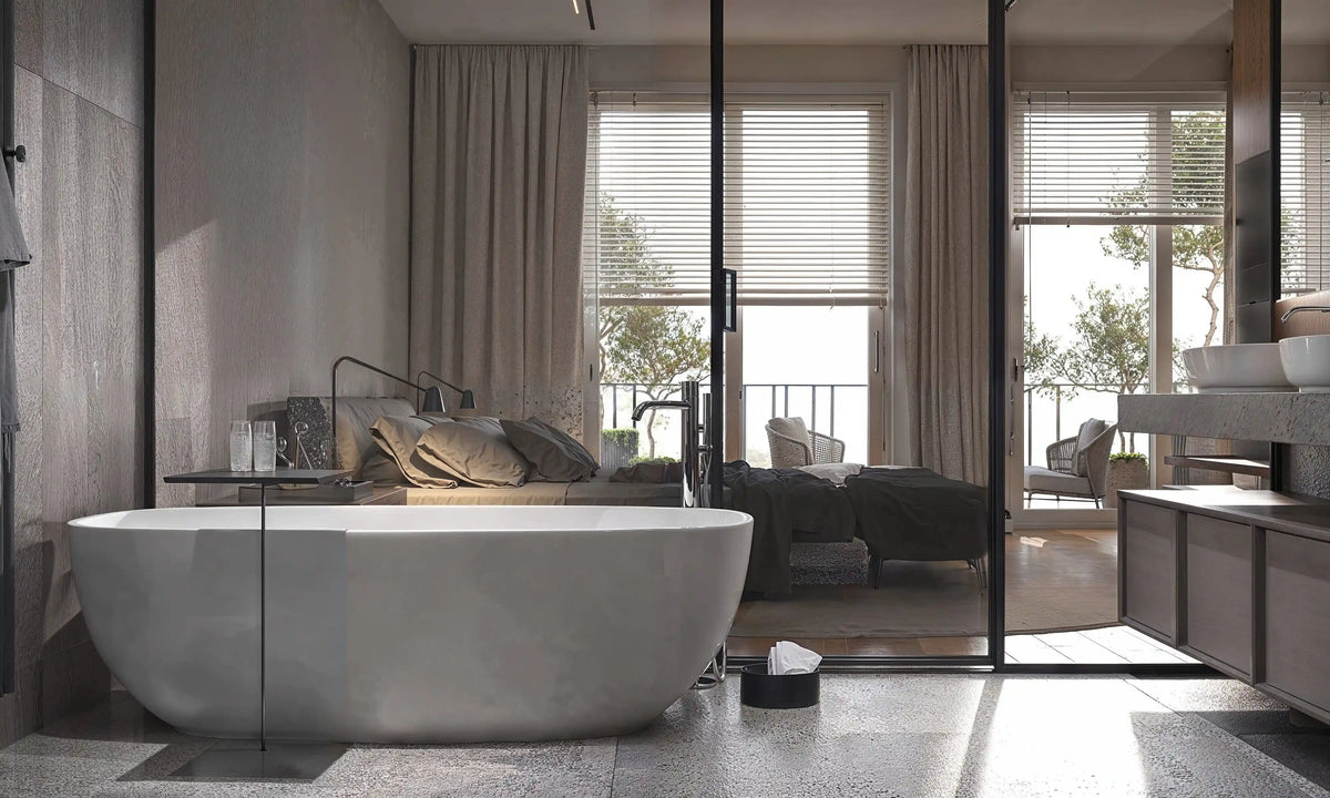Modern oval freestanding bathtub in a luxury bedroom suite with large windows.