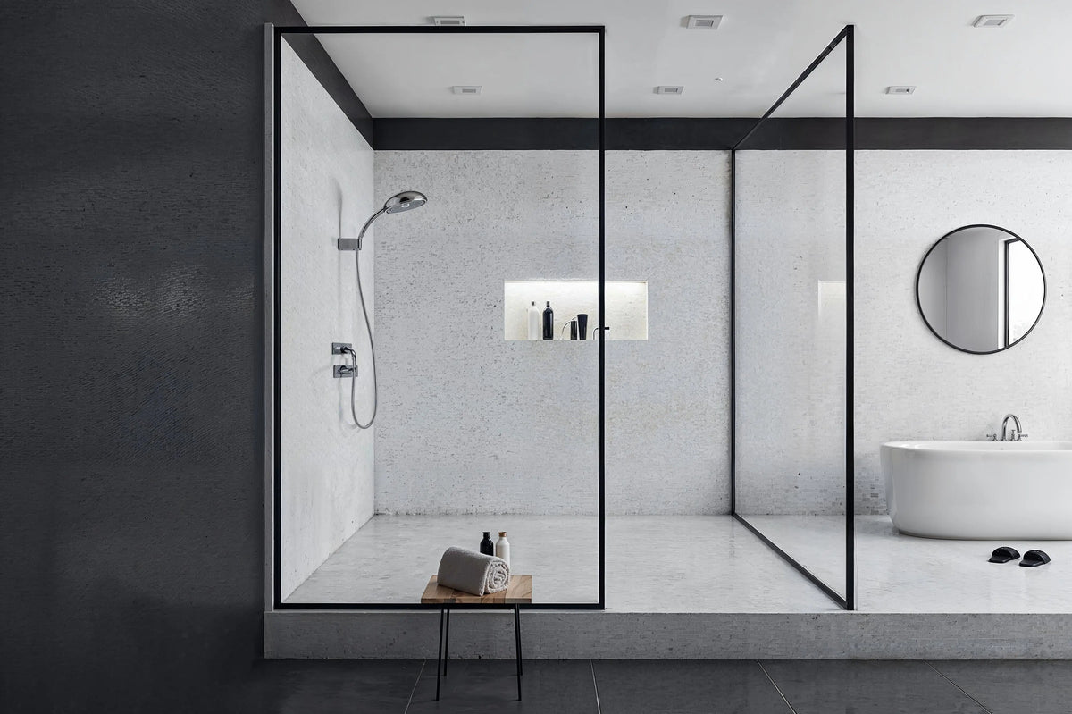 Modern bathroom featuring a black framed glass shower door and a white freestanding bathtub.