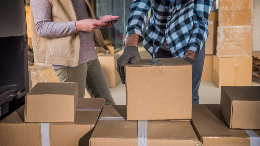Shipping supplies and people discussing the process for the delivery of the boxes.