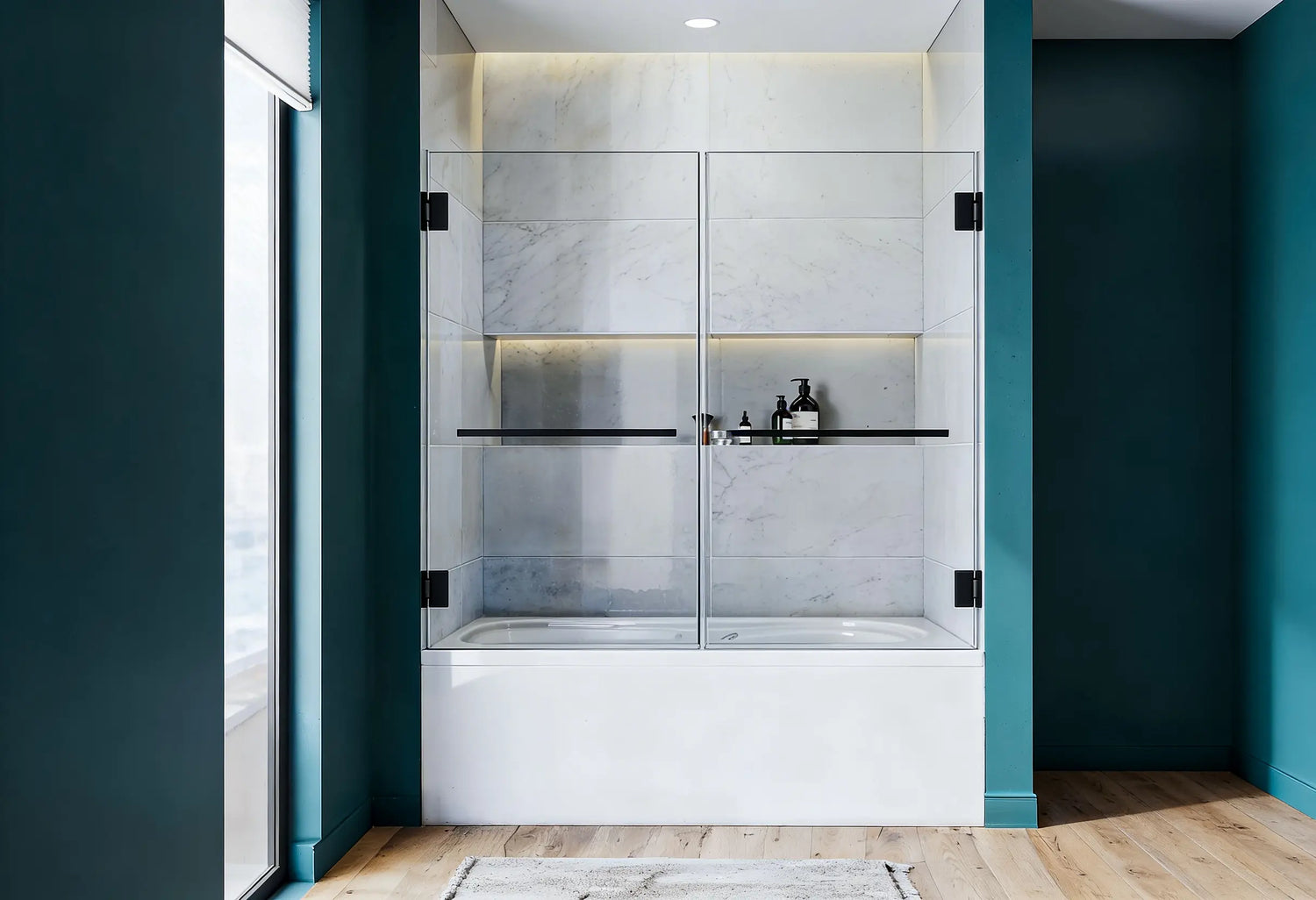 Frameless clear glass bathtub doors with sleek black hardware in a modern bathroom featuring deep teal walls and marble tiling.
