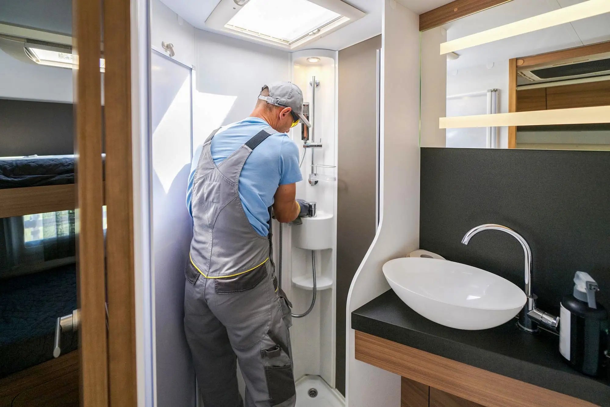 Installer working on a compact shower enclosure kit in a modern bathroom.