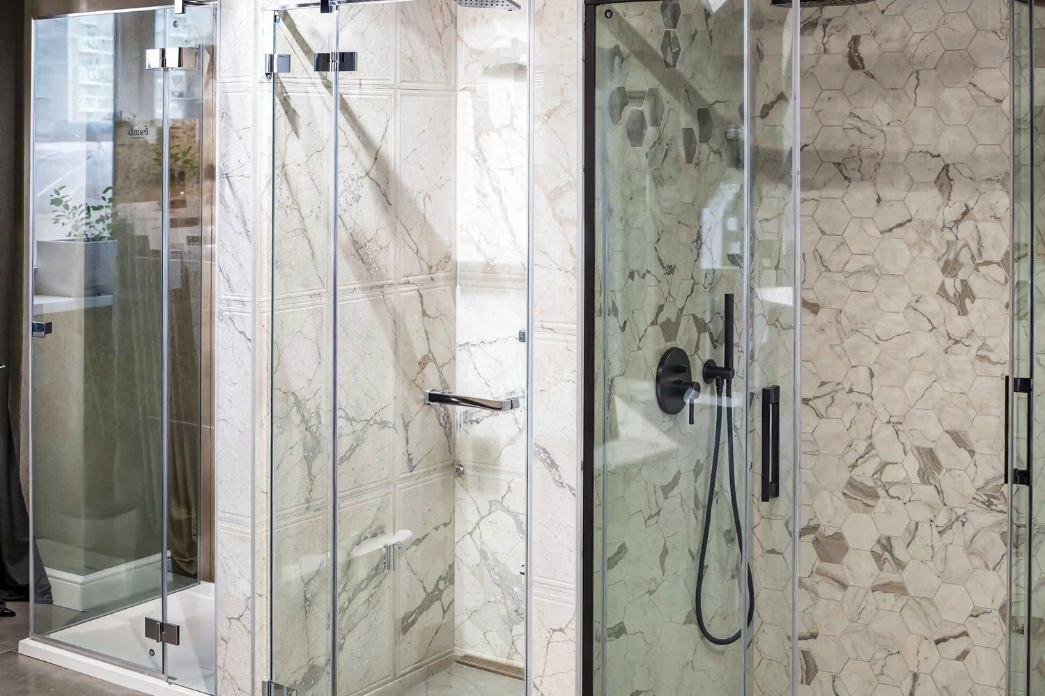 A brightly lit showroom display featuring a variety of modern Dreamwerks shower enclosures and frameless shower doors with different hardware finishes, set against a backdrop of clean tile and contemporary bathroom fixtures.