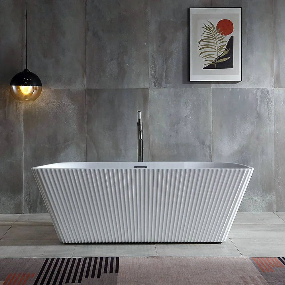 Modern Dreamwerks glossy white fluted freestanding bathtub in a bathroom with gray tiled walls and a framed picture.