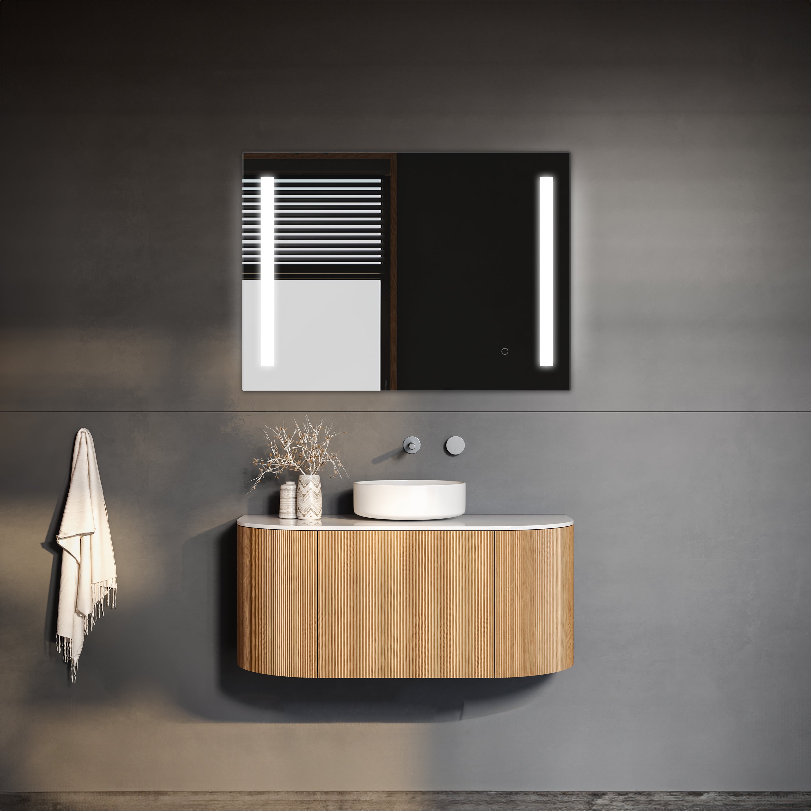 Modern minimalist bathroom vanity with round basin, illuminated by a TREVISO LED mirror with an integrated defogger, and stylish pendant lights against a dark gray wall, accompanied by a neatly hung towel and