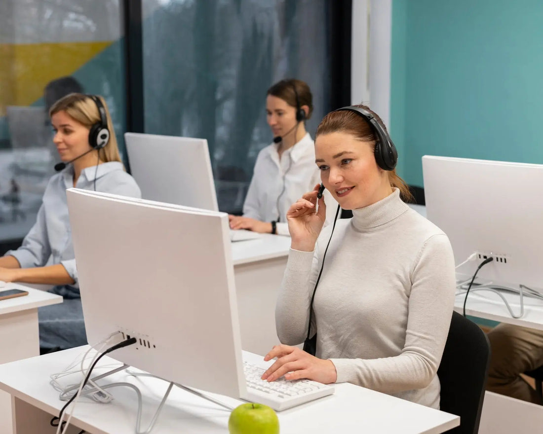 Call center agents working at their desks with computers and headsets.