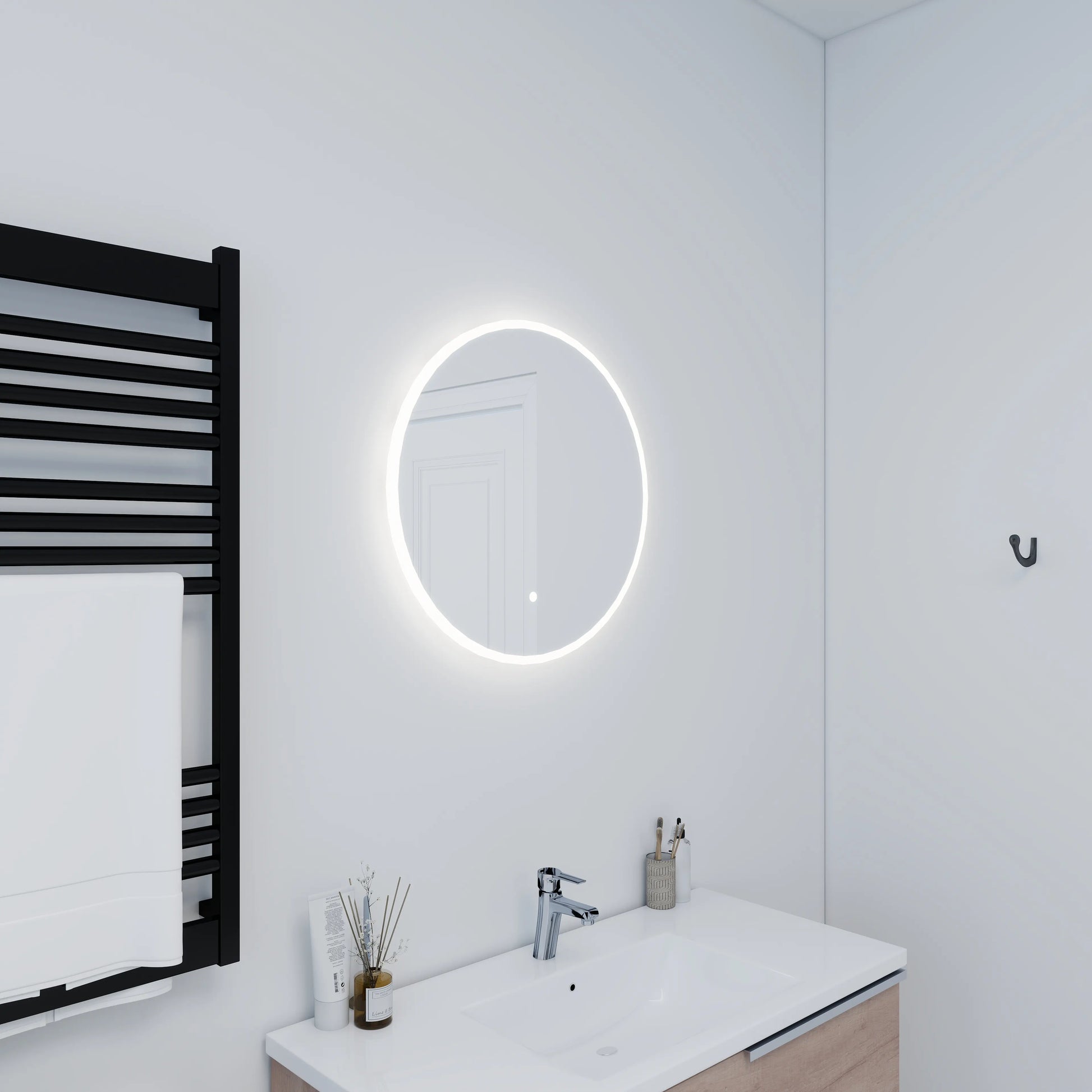 Modern bathroom with a round illuminated mirror, sink, and towel rack.