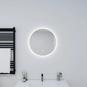 Bathroom with a round illuminated mirror and black towel radiator.
