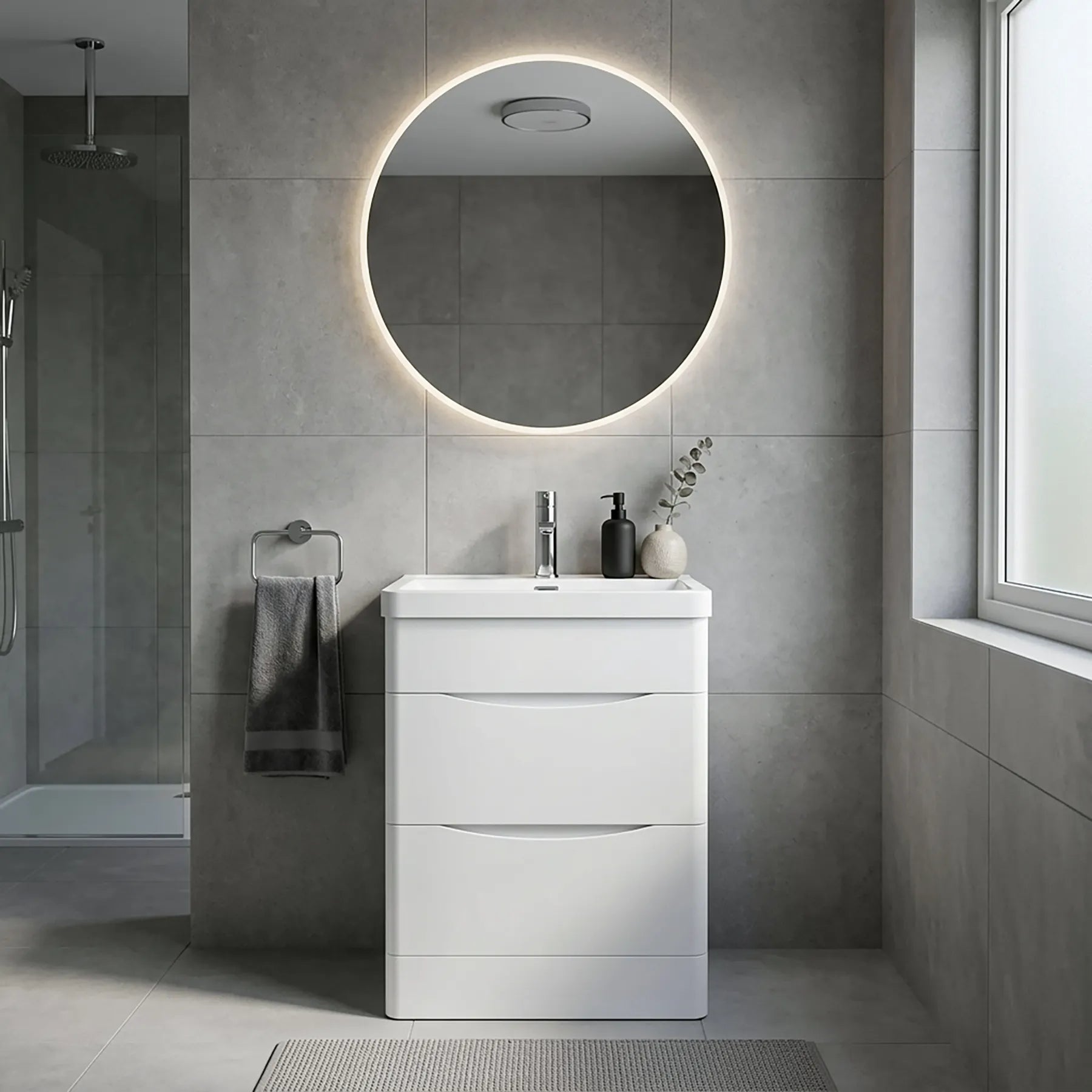 Bathroom with a white vanity unit, round mirror with lighting, and gray tiles.