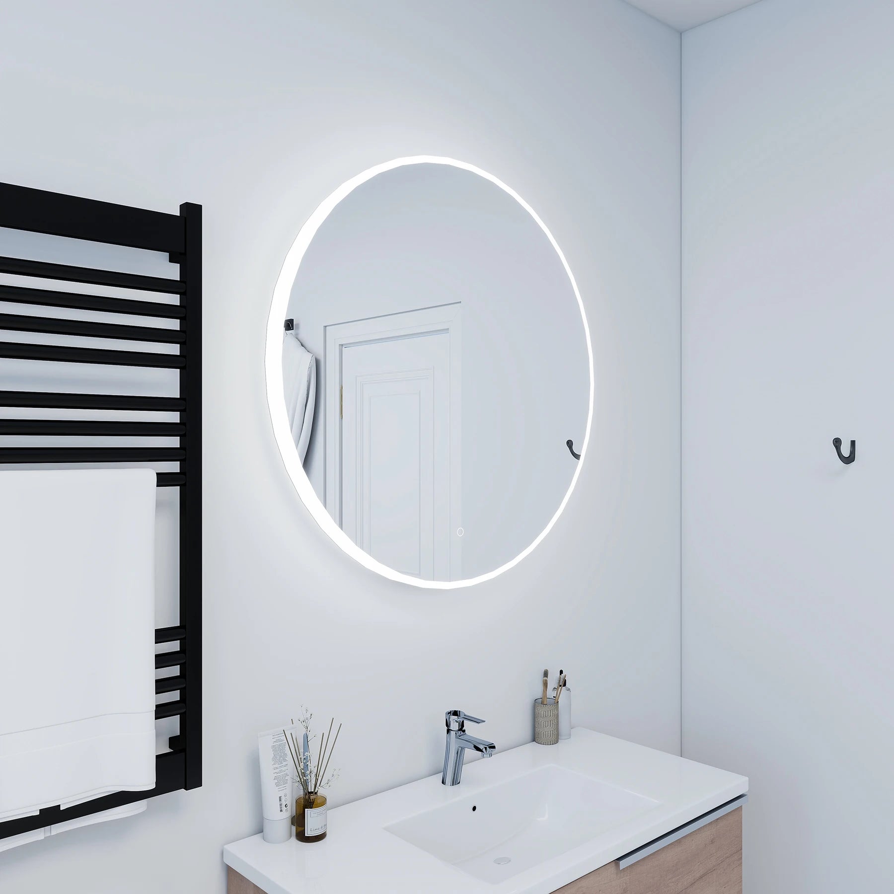 Bathroom with round illuminated mirror, sink, and towel rack.