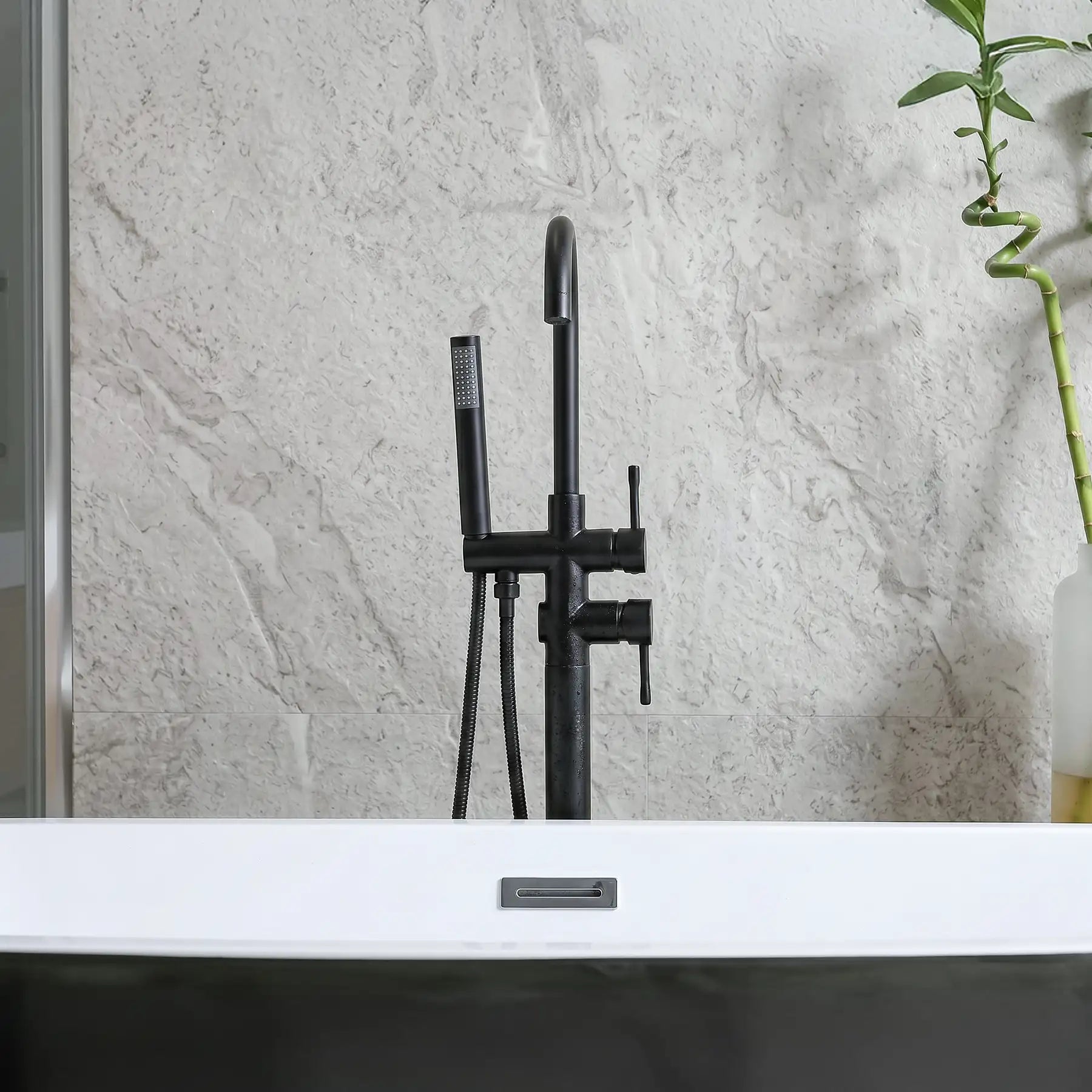 Black shower faucet set against a light gray tiled wall.