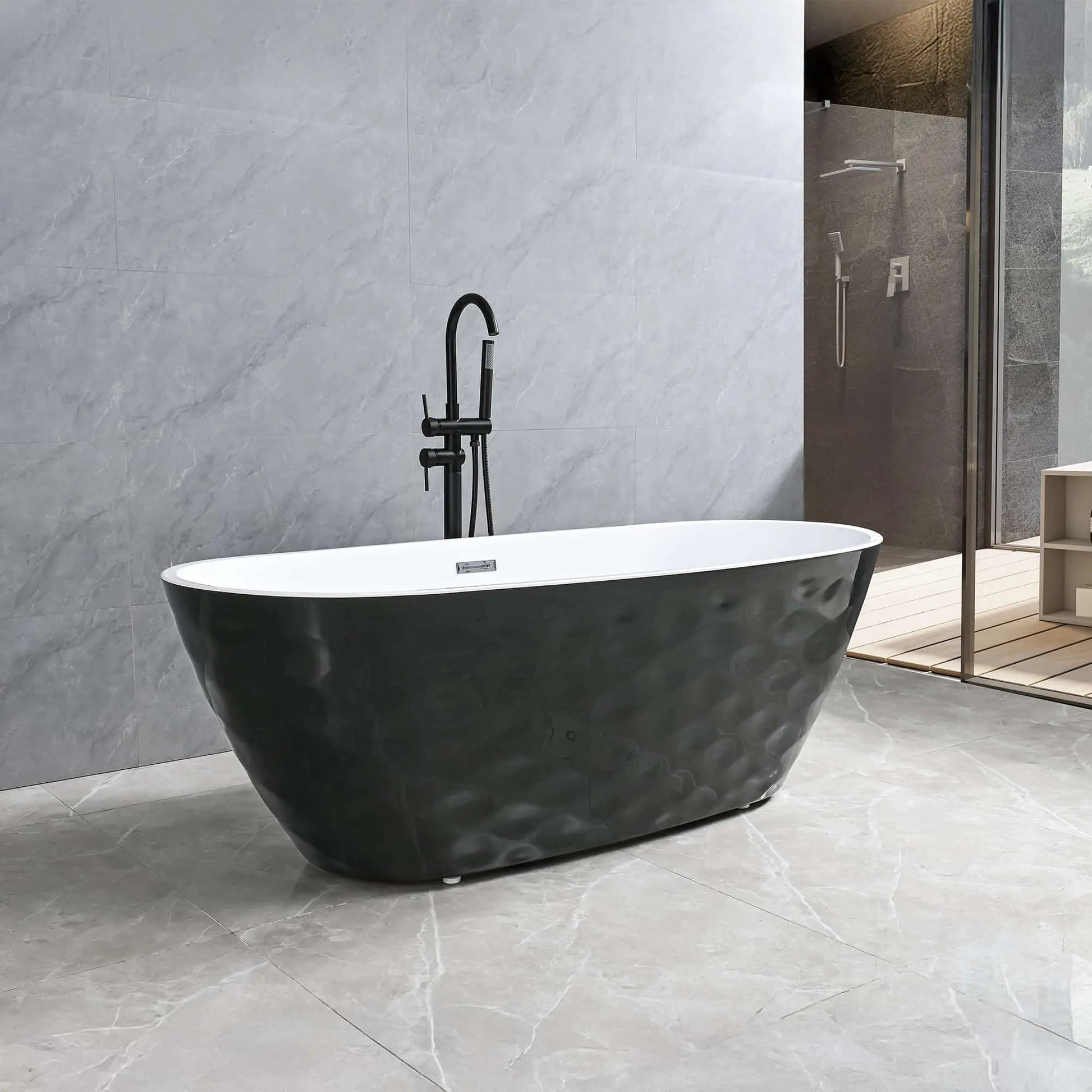 Dreamwerks Corvino Contemporary bathroom featuring a freestanding oval bathtub with a black, textured, wavy exterior skirt and a white interior. The tub is paired with a matte black floor-mounted faucet and is set against large format gray marble-look tile walls and floor. A walk-in glass shower enclosure is visible in the background.