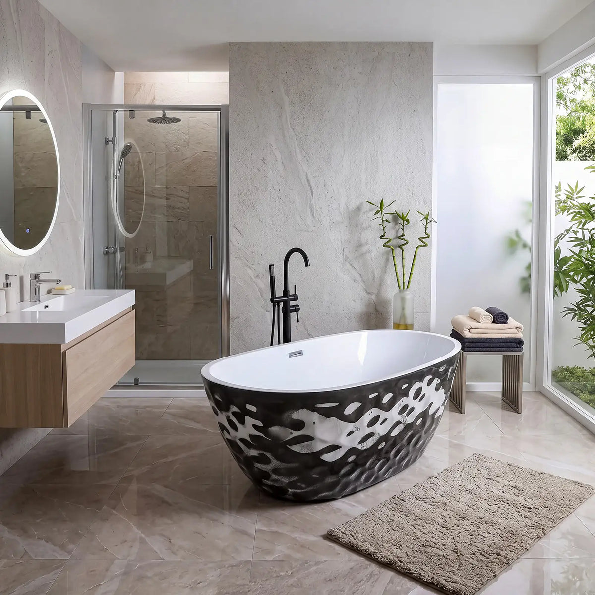 A modern freestanding oval bathtub with a black and white wavy pattern, set in a contemporary bathroom with a marble-look tiled floor, a glass shower enclosure, and a beige bath rug.