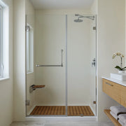 Modern bathroom with a glass shower enclosure, wooden bench, and sink.