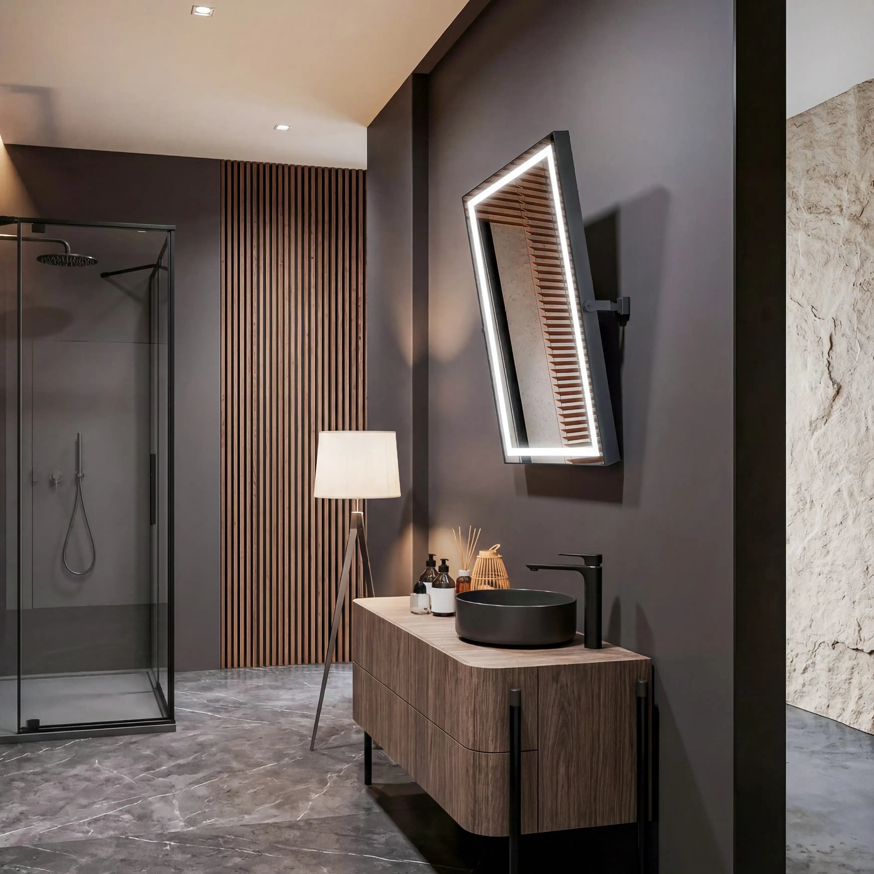Modern bathroom with wooden vanity, black sink, and illuminated mirror.