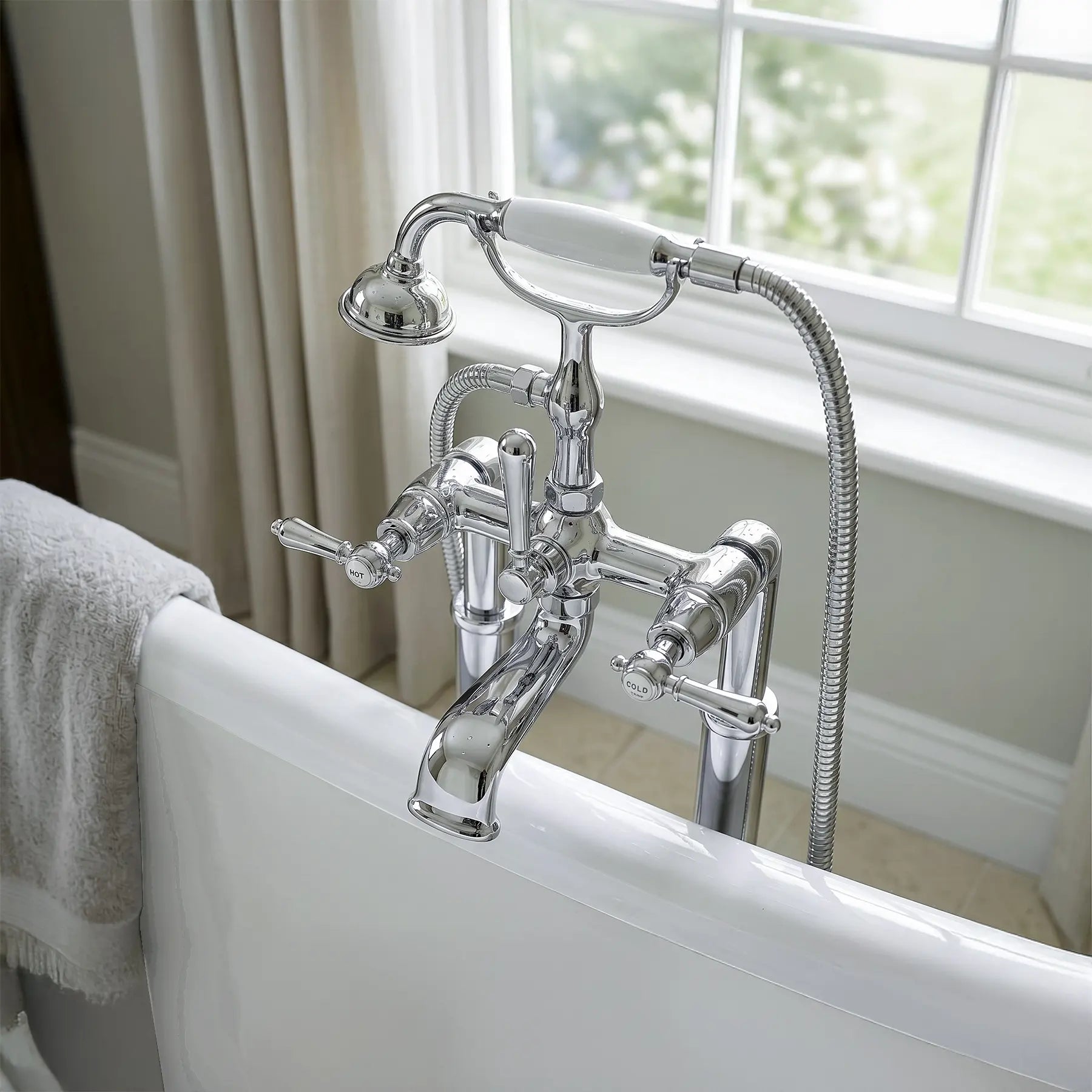 Chrome bathtub faucet with handheld shower head in a bathroom setting.