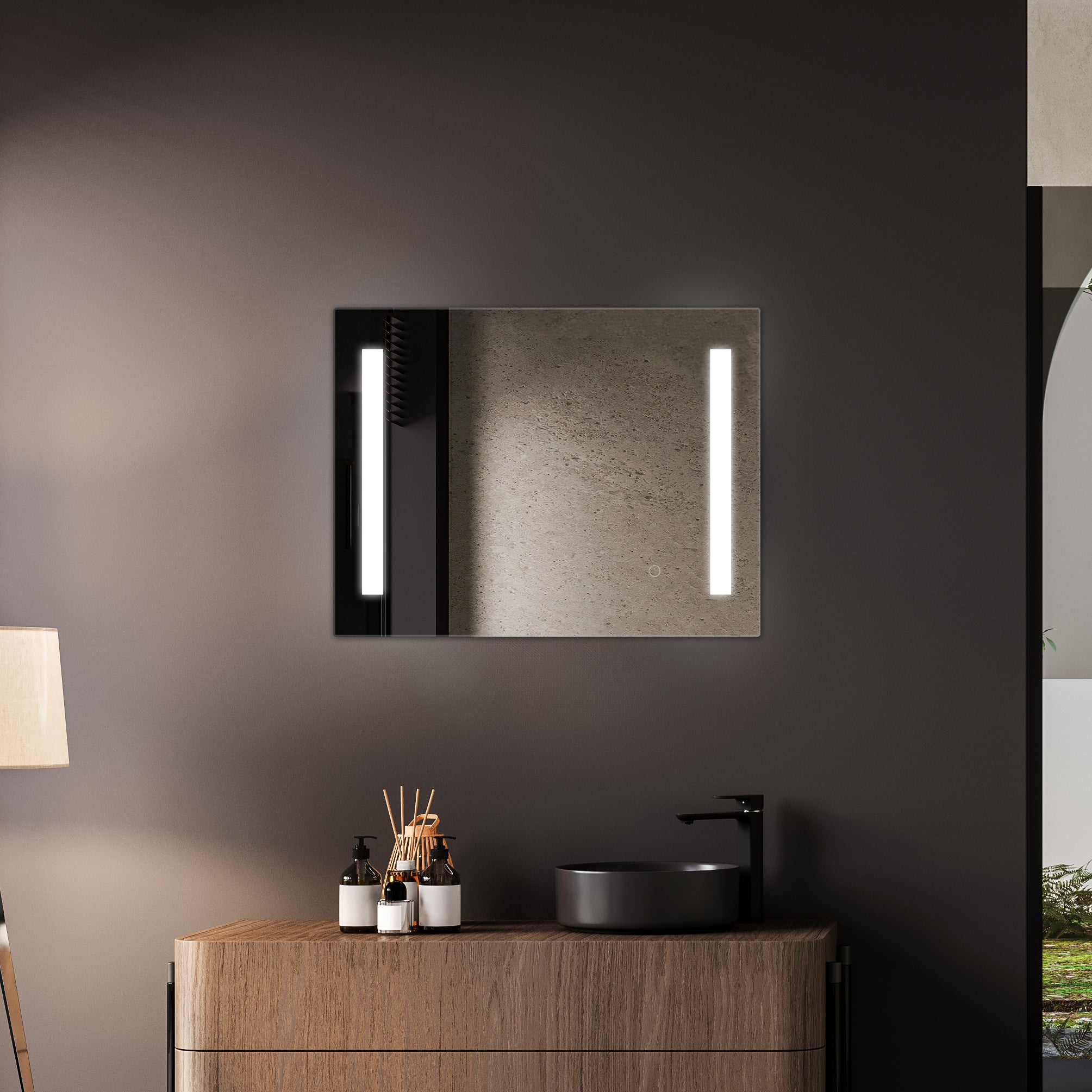 A modern, illuminated TREVISO LED bathroom mirror with an integrated defogger hangs above a wooden vanity cabinet, complemented by minimalist decor and a soft, ambient light.